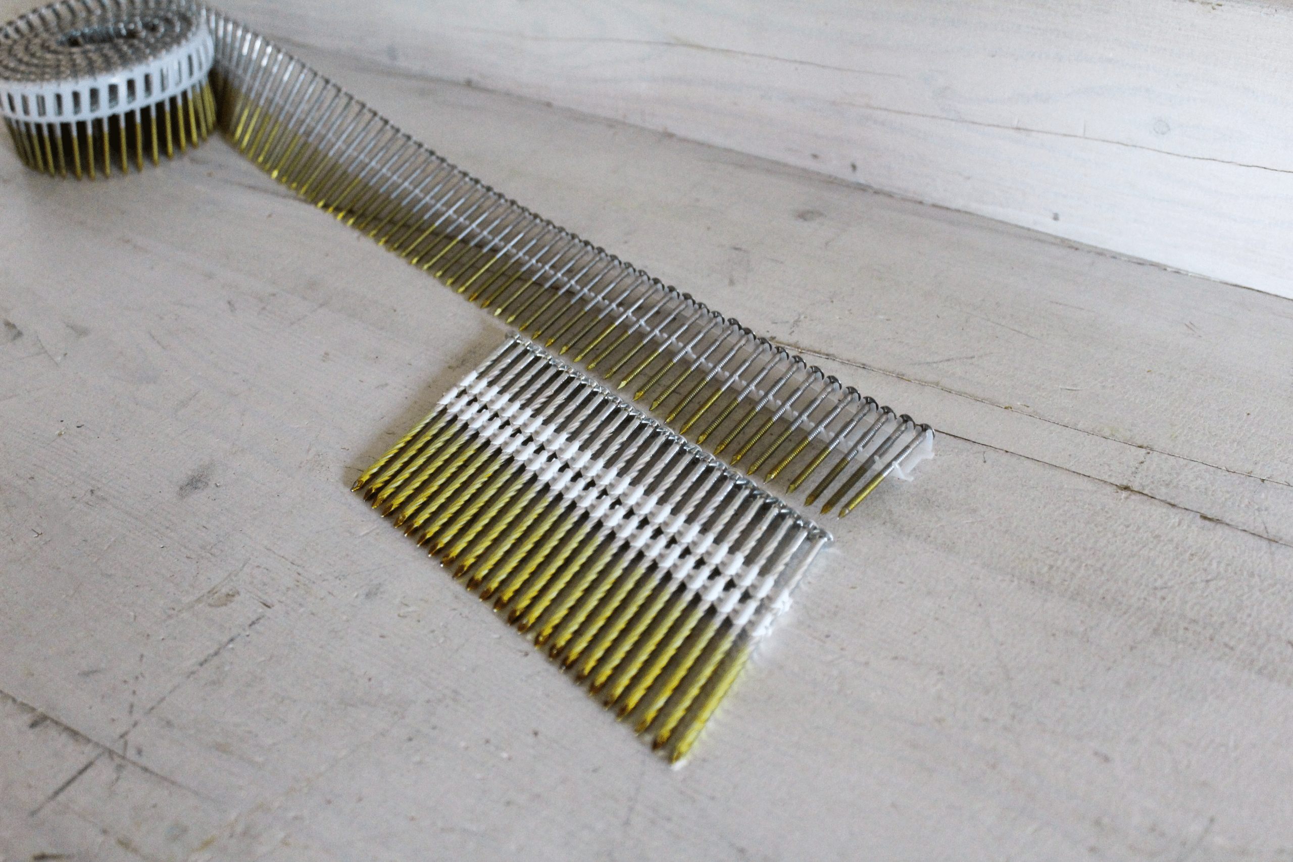 Coilnails en spijkers op strip naast elkaar